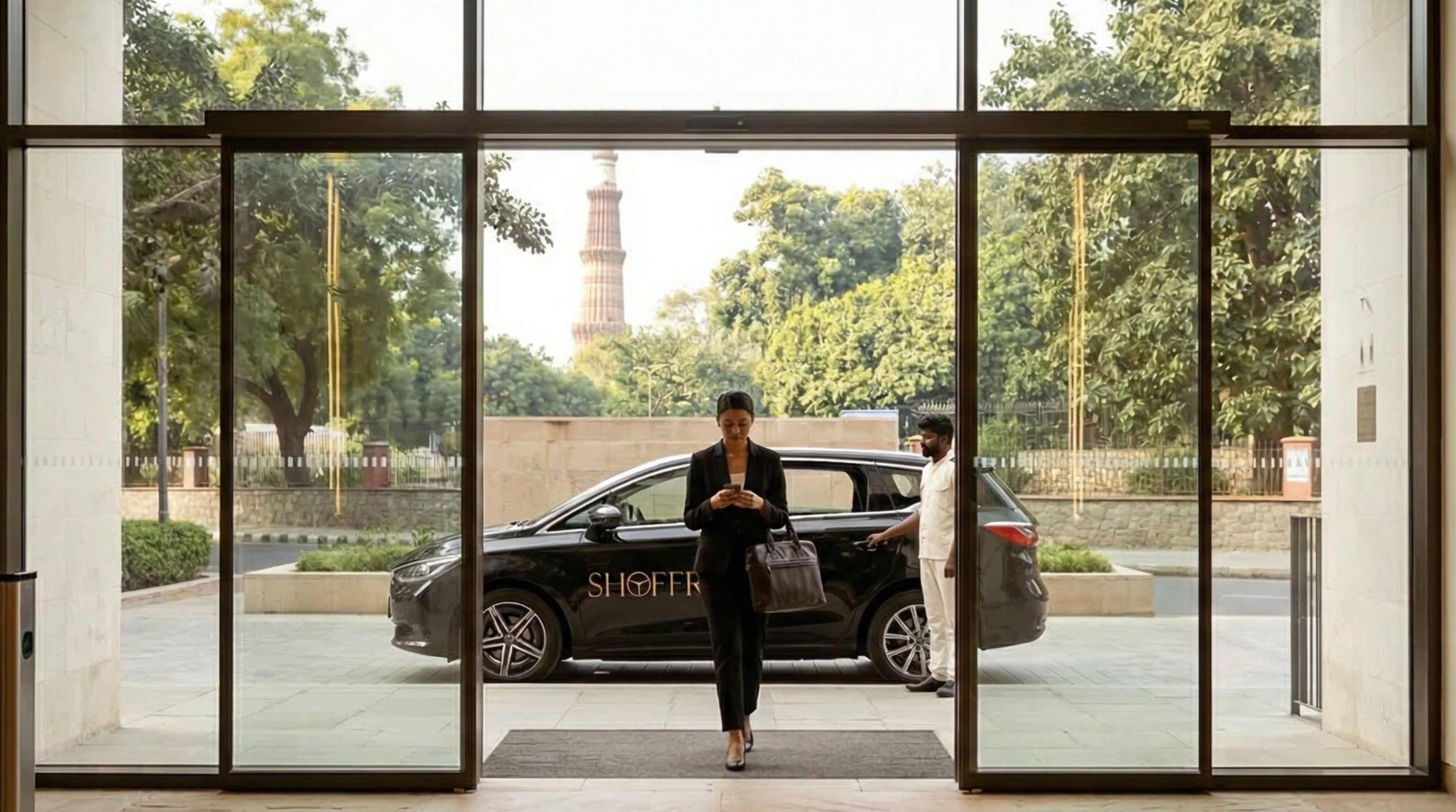 A Shoffr car parked at the entrance of a Delhi hotel, with the Qutub Minar visible through the glass doors (image is AI-generated, per Vikas Bardia's tweet)