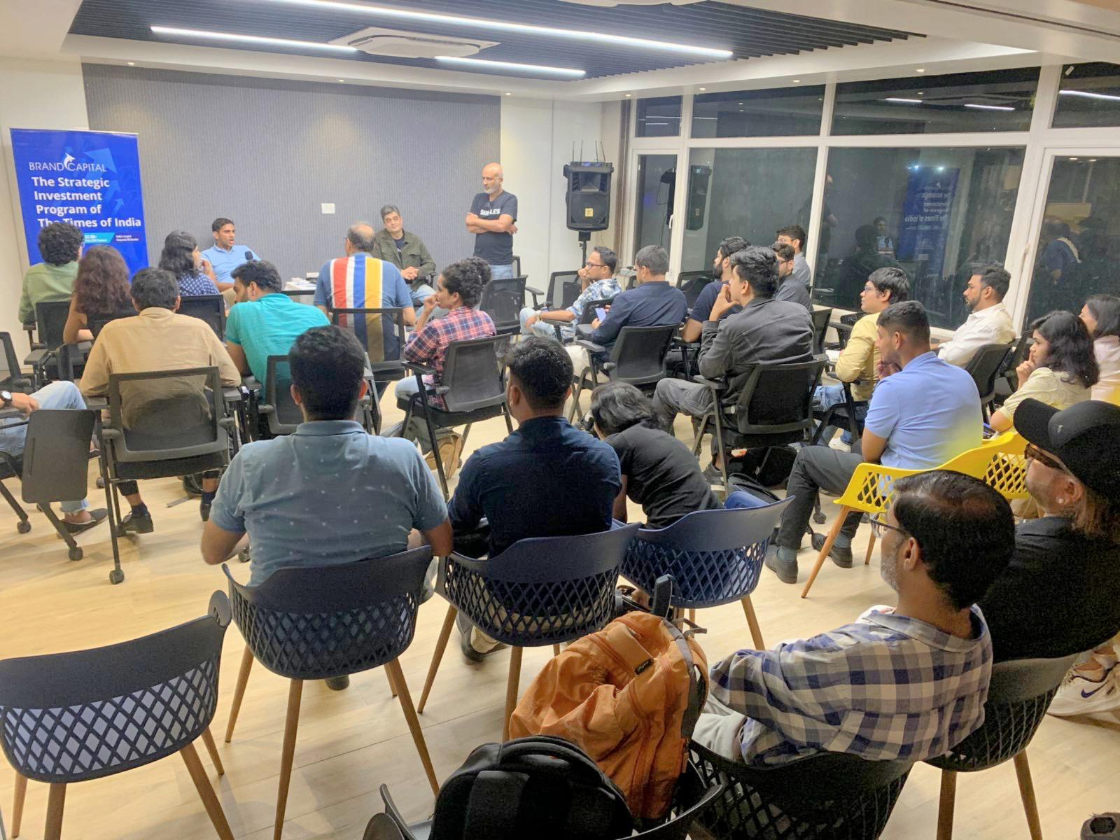 D2C Founders Mixer at the Times of India Building in Fort, Mumbai: rows of founders seated in a hall with Arjun Vaidya and Abhishek Daga at the front and a Brand Capital banner on the wall
