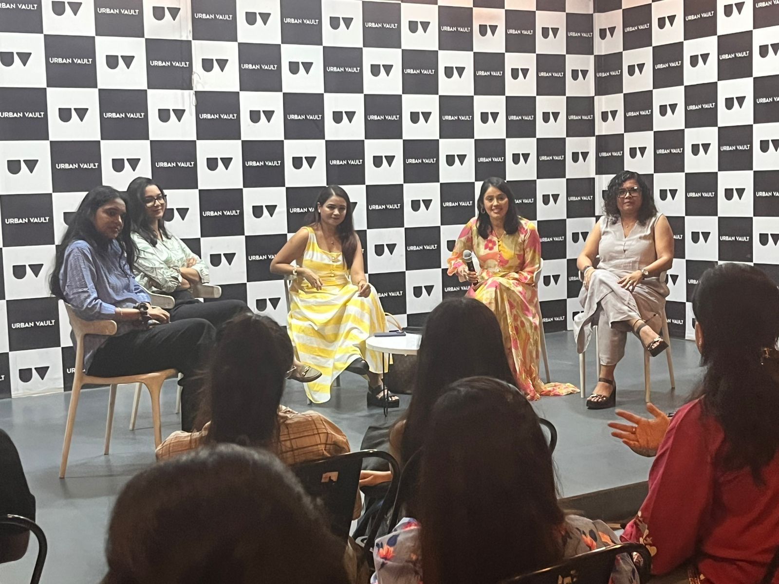 Panel at the eChai Women Founders Initiative in Bengaluru: five women panelists seated on stage in front of an Urban Vault checkered black-and-white backdrop, with the audience visible in the foreground