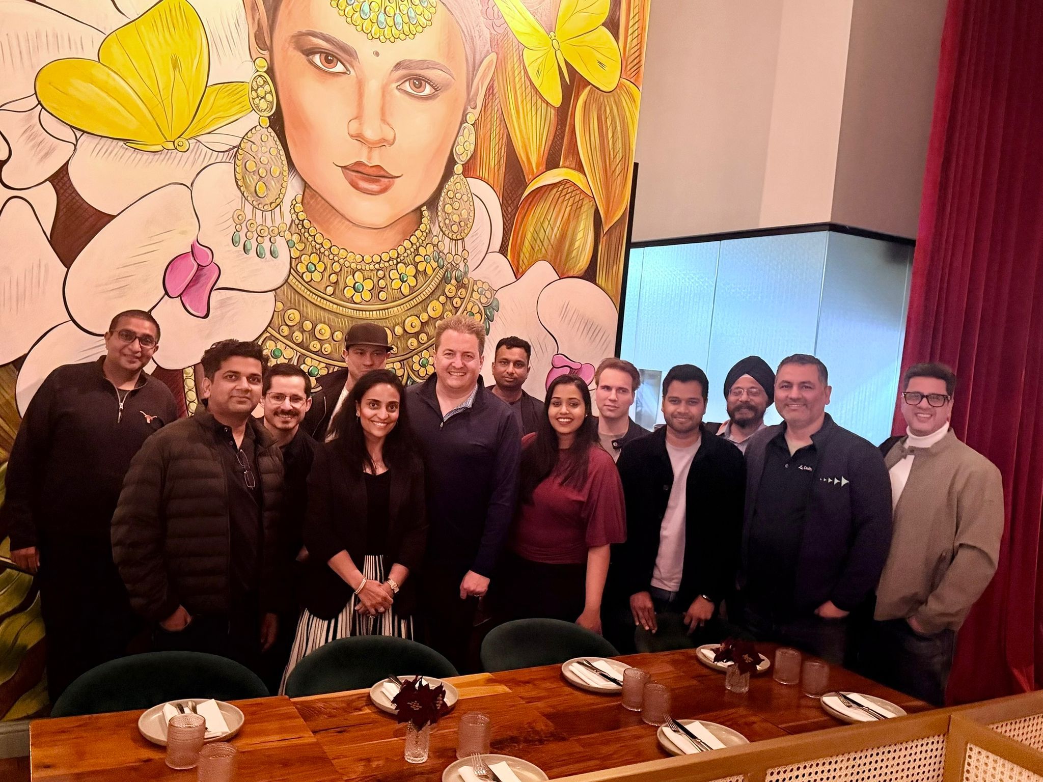 Group photo at the eChai CEO Dinner in San Francisco: Khyati Brahmbhatt and Murray Newlands with founders past $10M in funding or ARR, standing before a vivid mural at the dinner venue