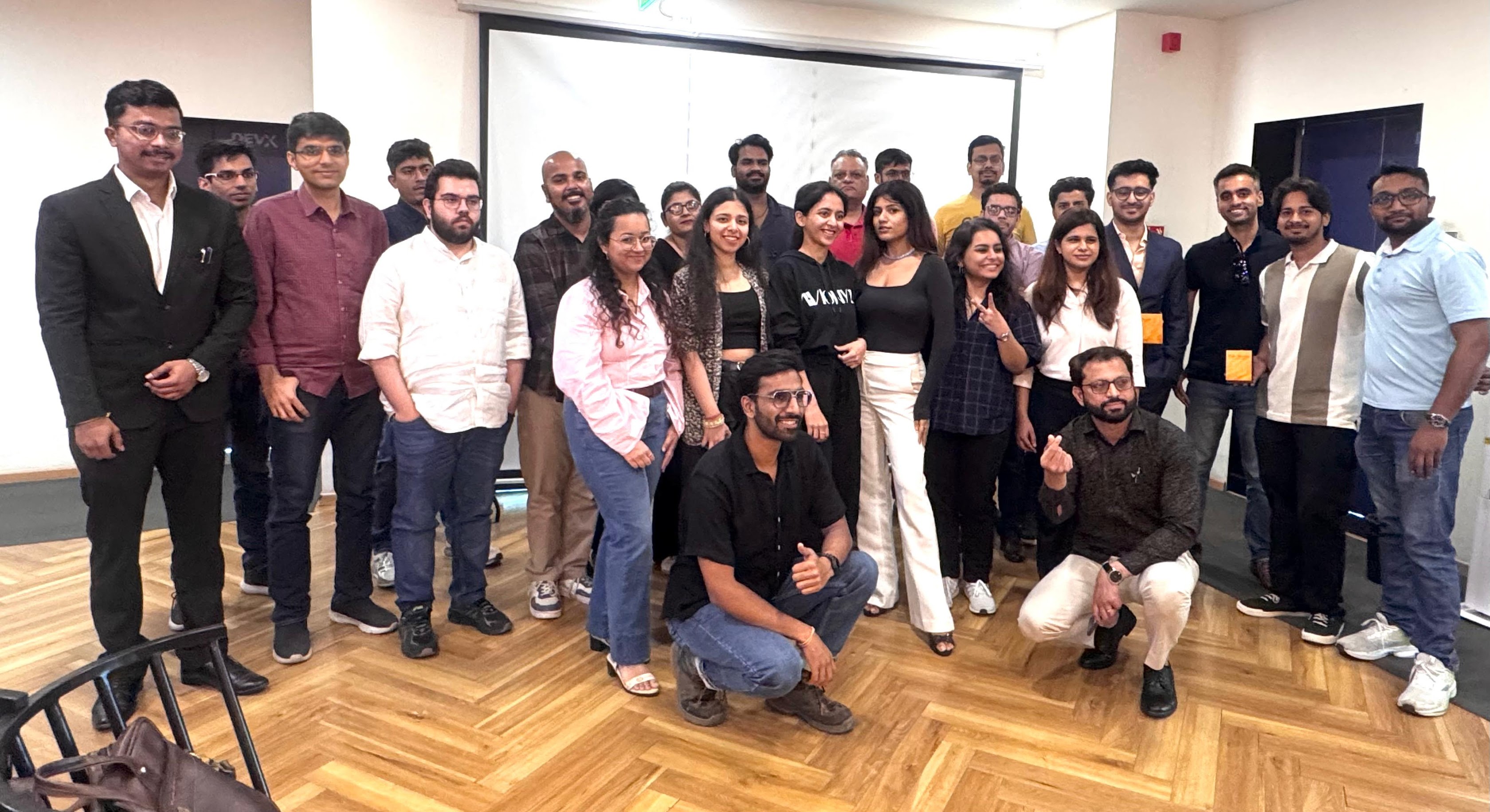 Group photo of the eChai Delhi-NCR Founder Circle at DevX Noida: 20+ early-stage founders and operators standing together in the DevX event room with the DevX signage on the wall behind them
