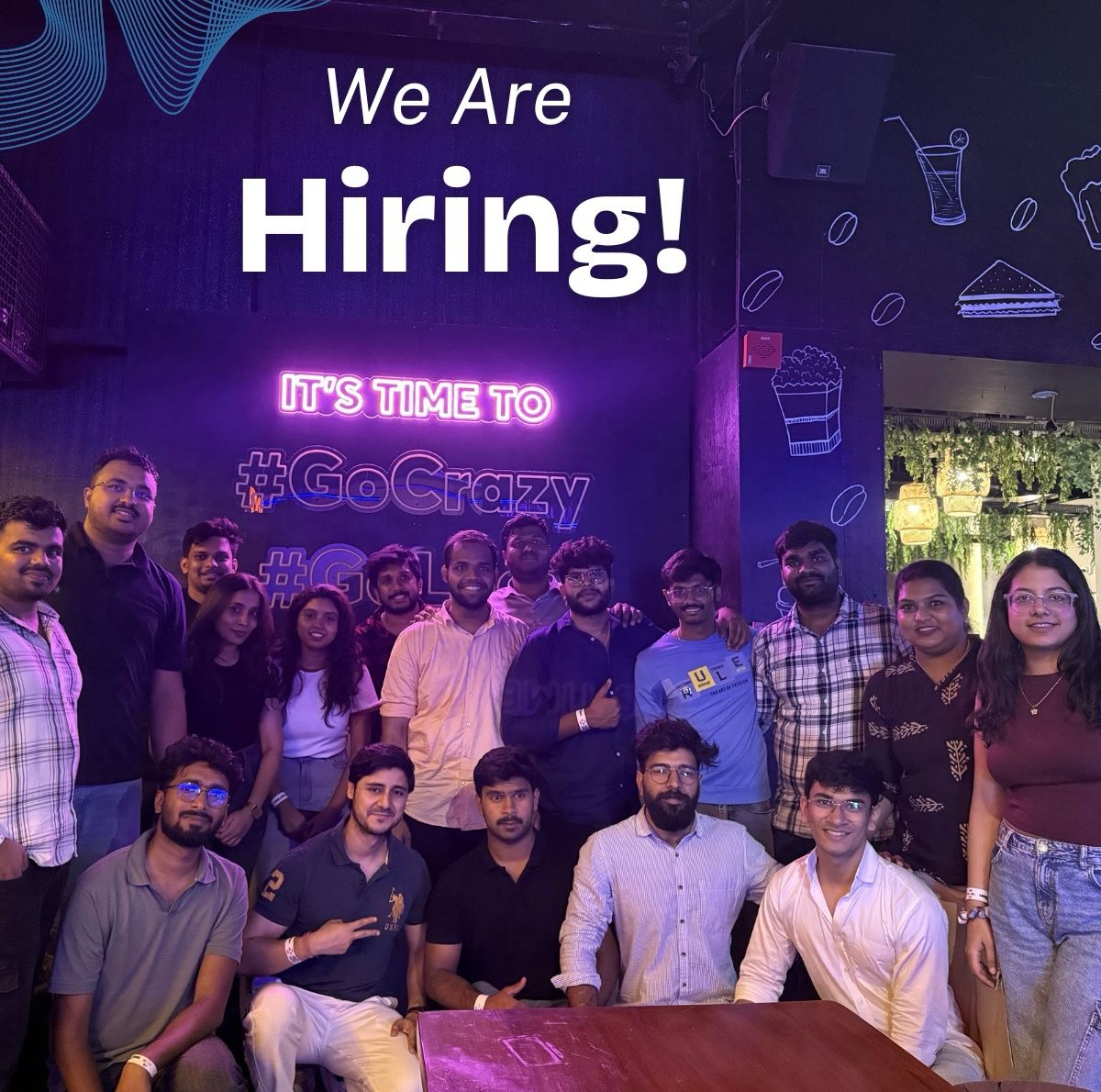 AI Palette team gathered under a 'We Are Hiring!' neon sign at their Koramangala office